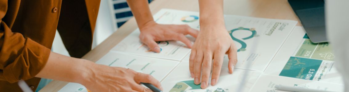 Krupni plan članova tima koji pregledavaju dokumente o certifikaciji